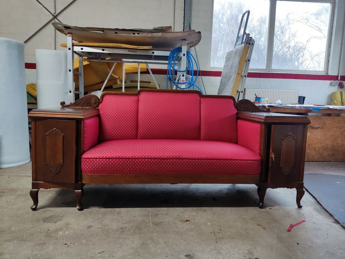 Antikes Sofa mit neu bezogenem rotem Stoff in der Werkstatt