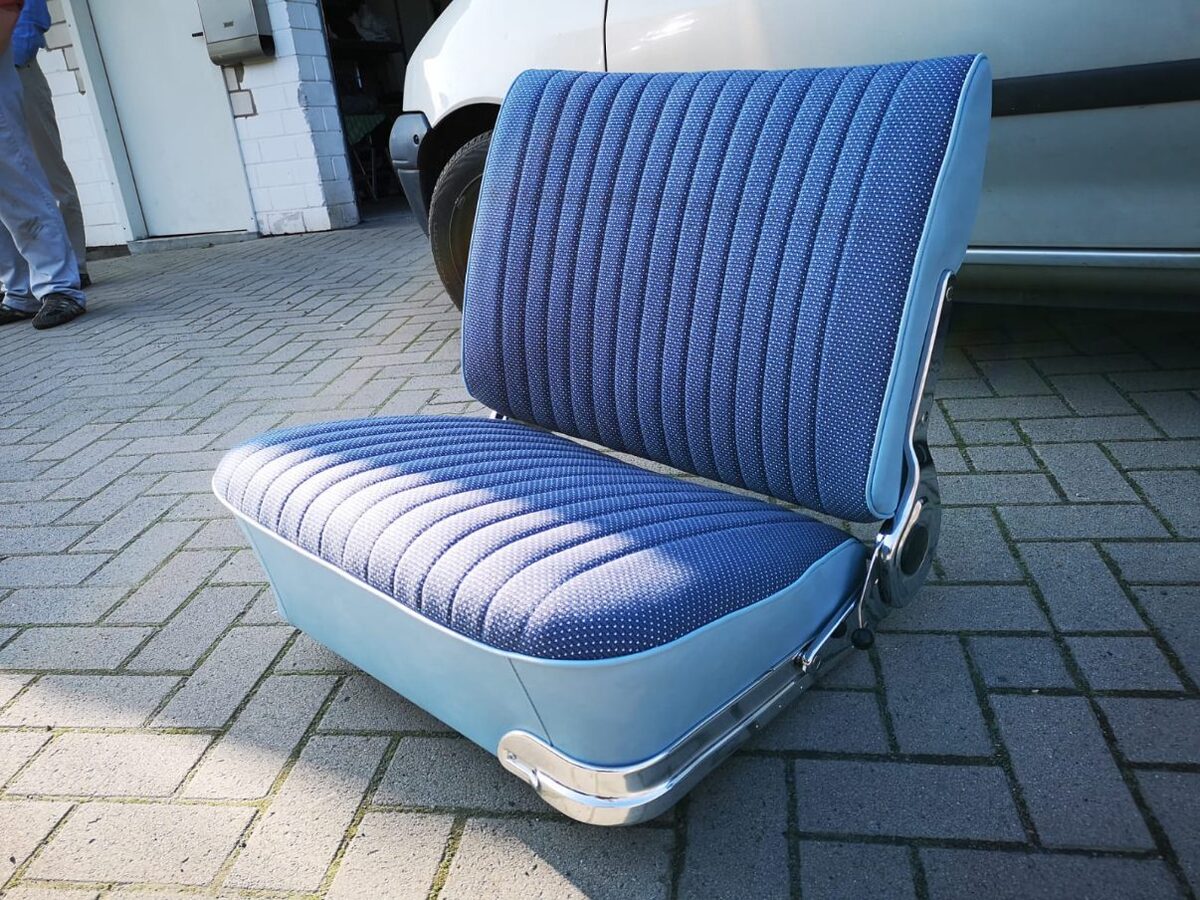 Neu bezogene Oldtimer-Sitzbank in Hellblau mit blauem Musterstoff und Chromleiste