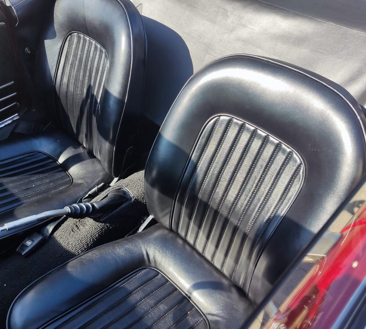 Zwei neu bezogene Oldtimer-Sitze in schwarzem Leder mit Längssteppung